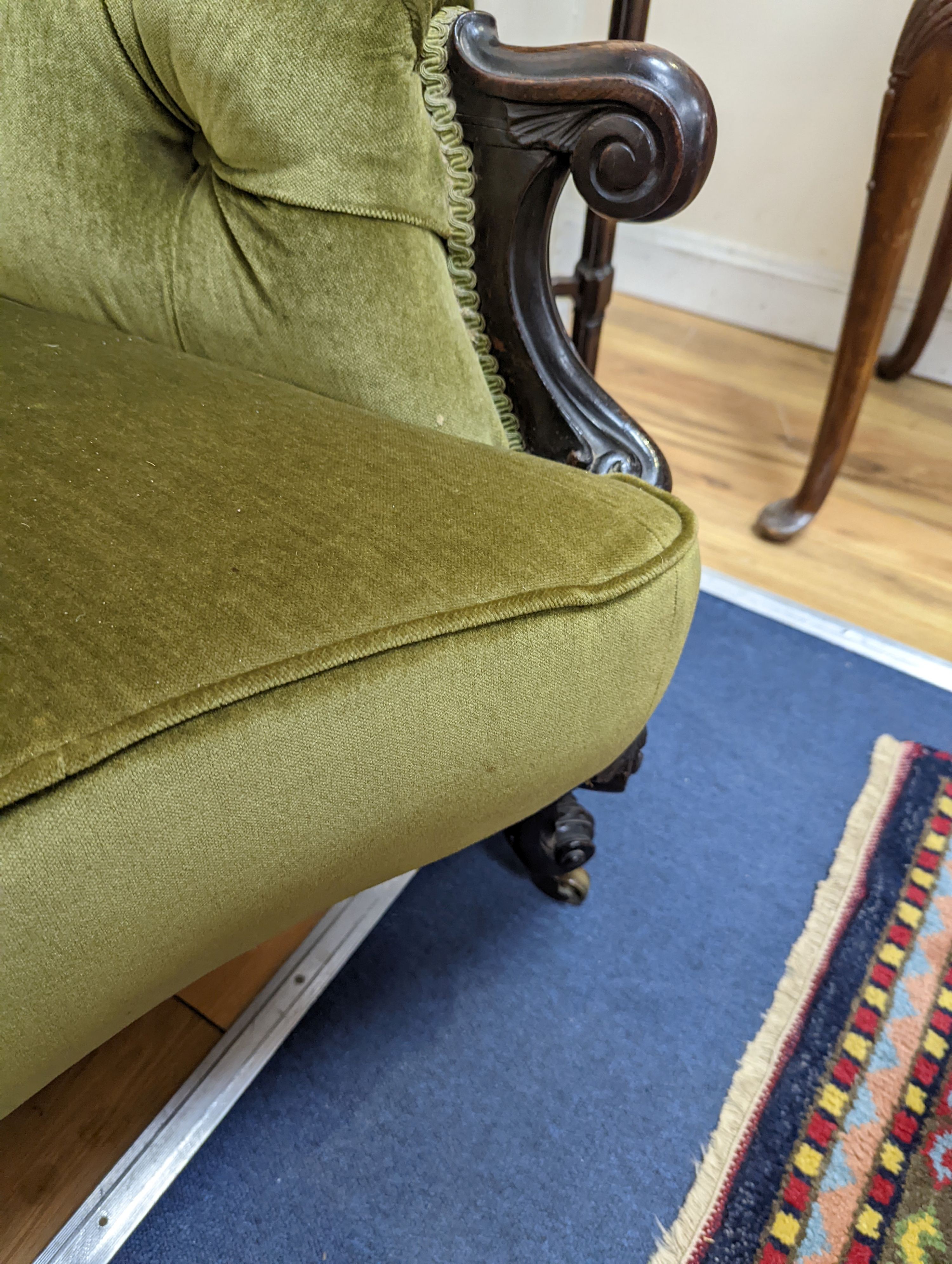 An early Victorian rosewood concave fronted two seat settee upholstered in buttoned green dralon, length 156cm, depth 77cm, height 80cm